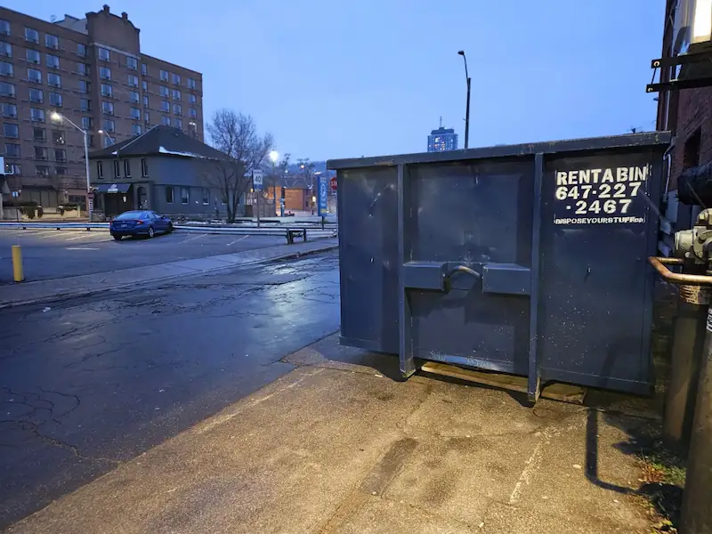 Barricaded dumpster with safety cones on a Burlington street