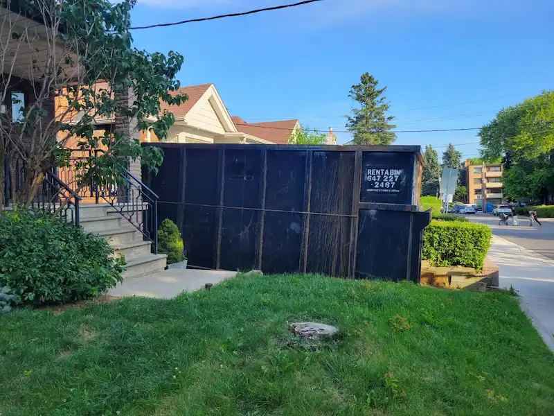 Inspector measuring clearance of a dumpster on a Vaughan street