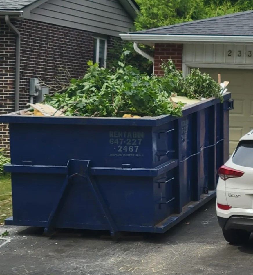 A 14 yard blue disposal bin placed on a residential driveway in Etobicoke for waste removal.
