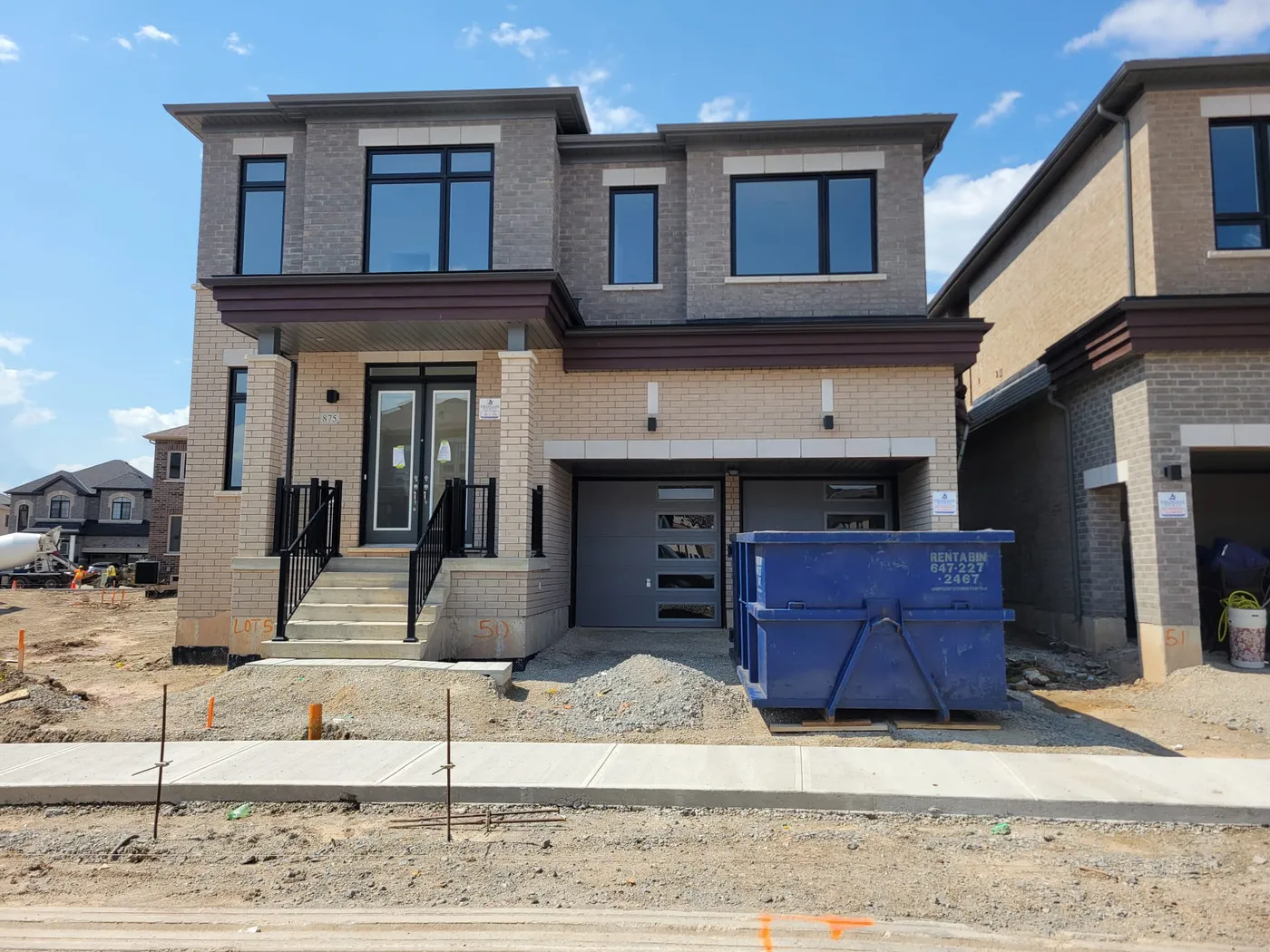 Large construction bin with safety reflective tape at a North York job site