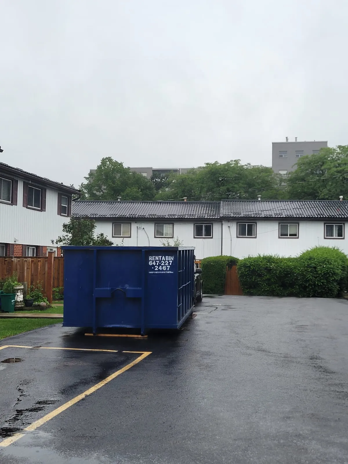 Large blue roll off container in a residential complex