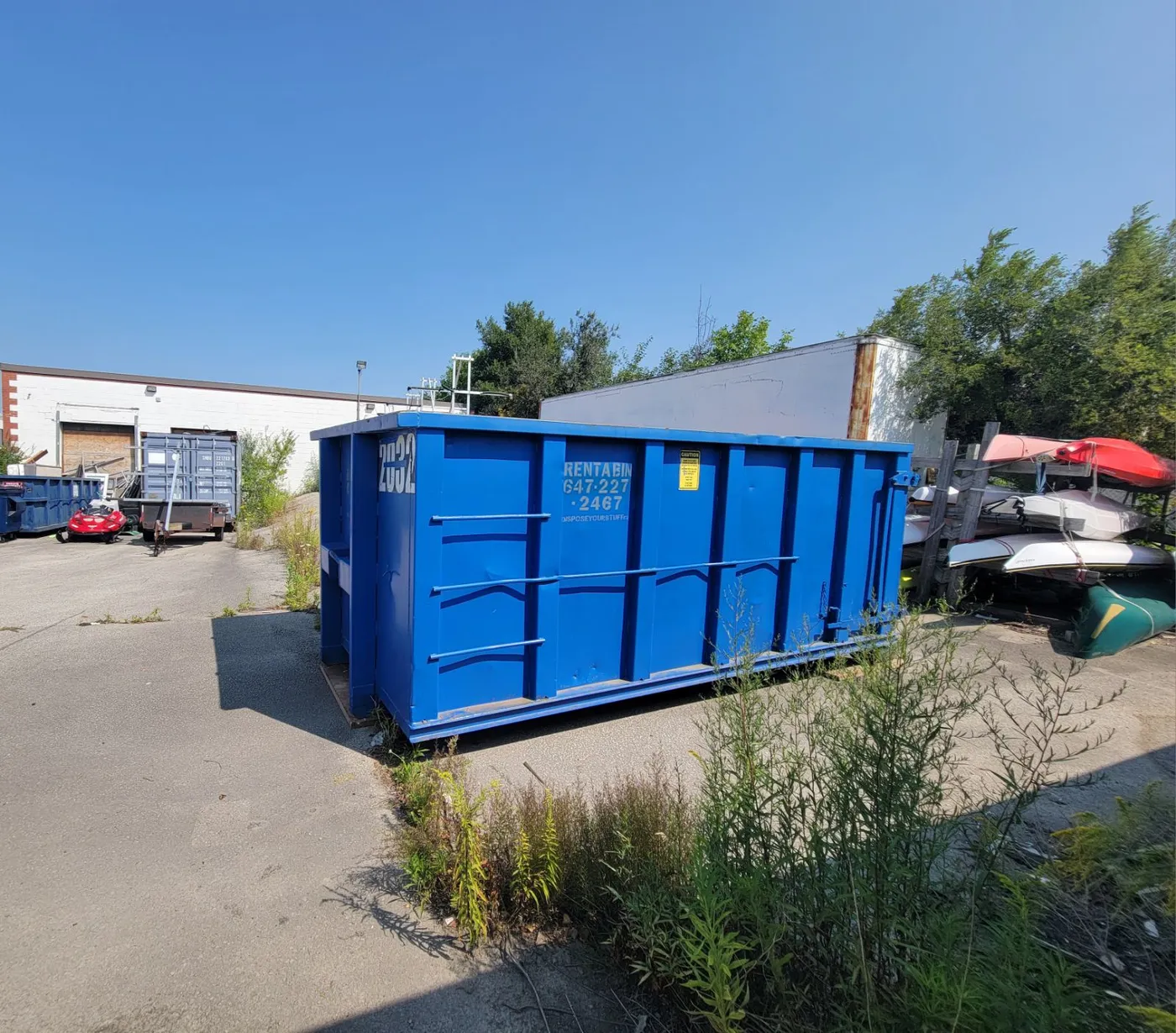 Large blue disposal bin on a residential property showing bin scale and clearance