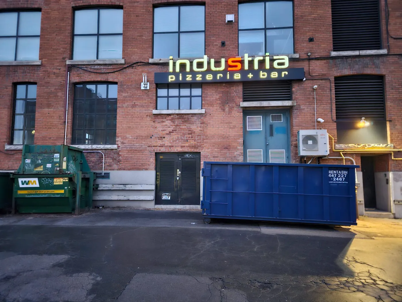 Large blue roll-off bin positioned for a Milton residential renovation project