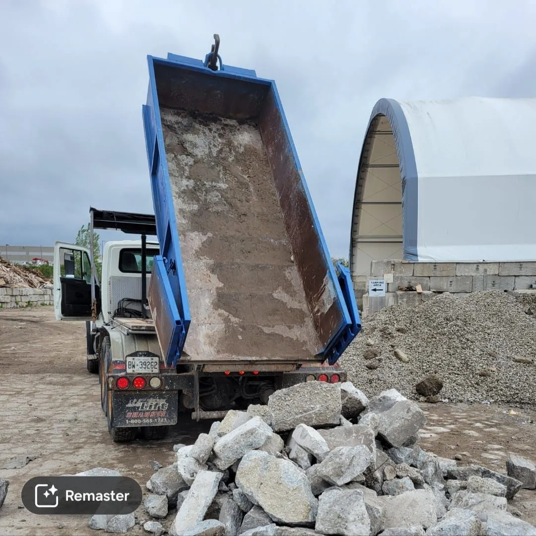 Roll-off truck unloading heavy concrete debris