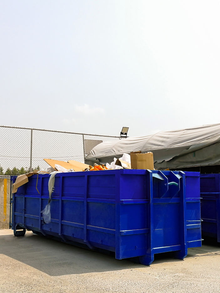 A blue disposal bin filled with sorted mixed waste materials